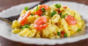 Scrambled Egg with Shrimp and Chopped Onions in a White Plate