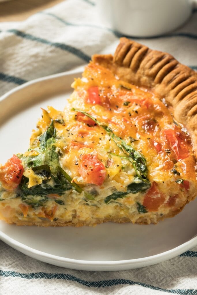 Slice of Veggie Quiche with Spinach and Tomatoes