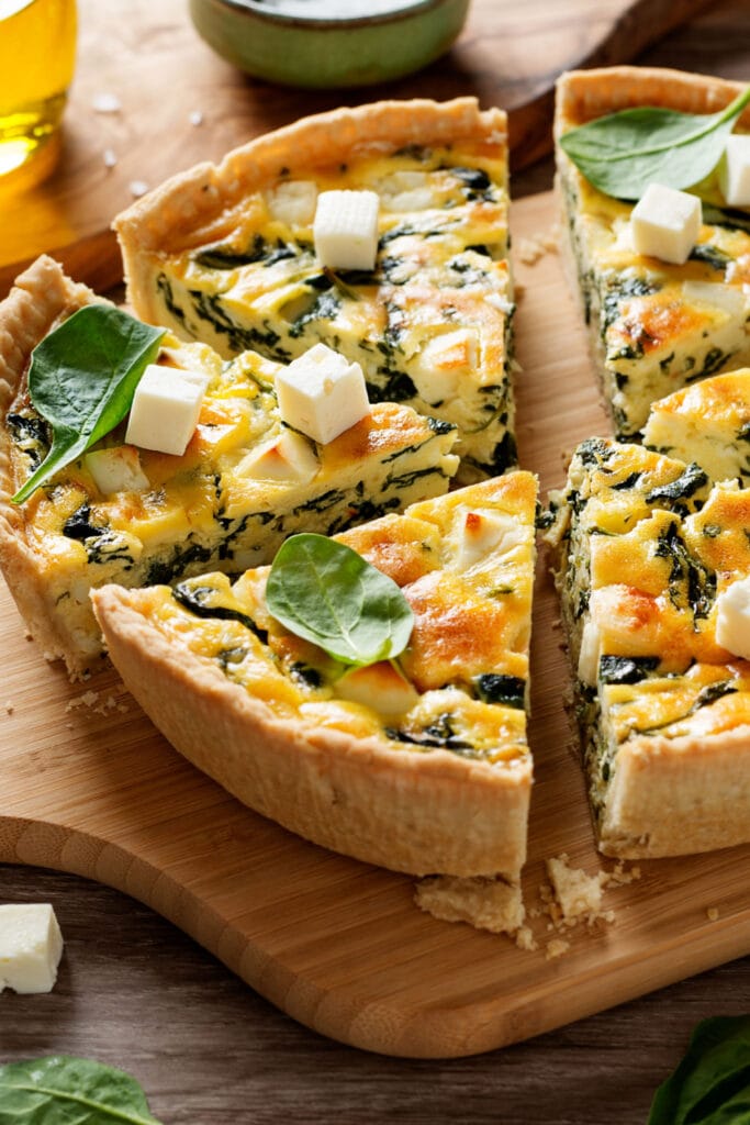 Spinach quiche sliced on a chopping board