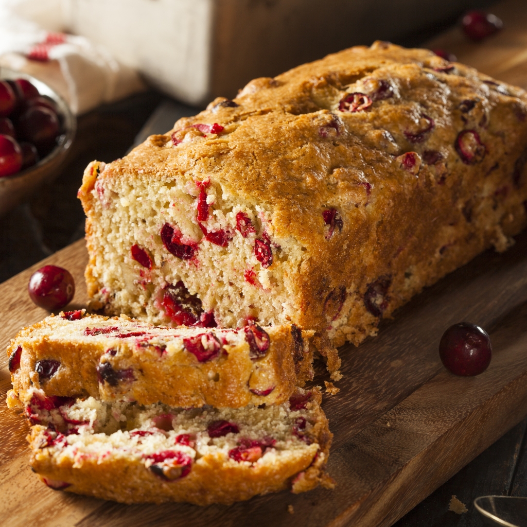 Sliced cranberry loaf bread on a wooden board. 
