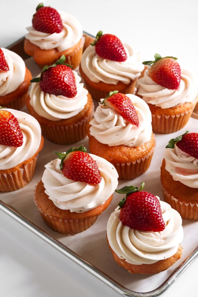 Sweet strawberry cupcakes with icing and fresh strawberries on top