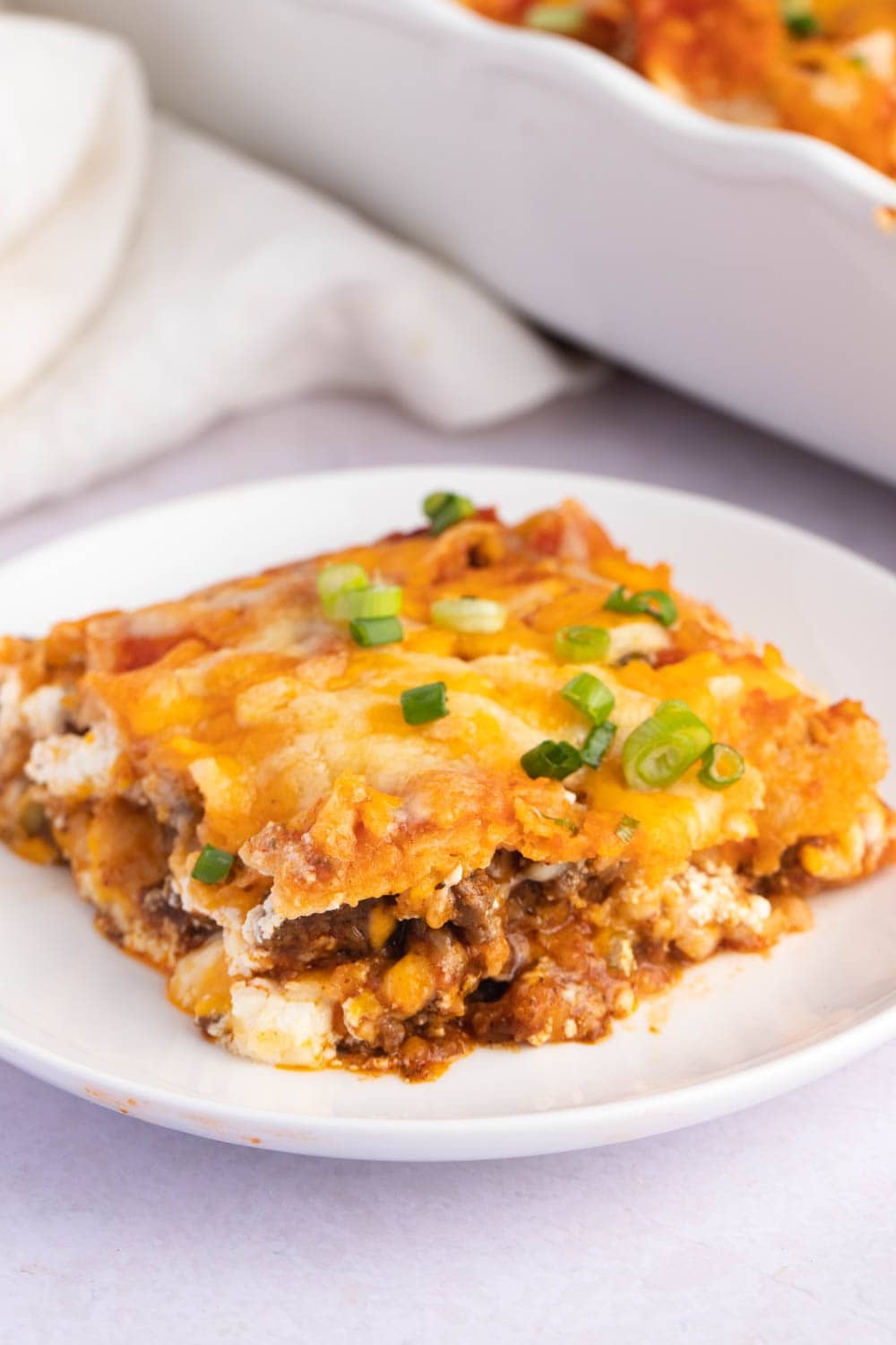 Portion of Cheesy Taco Lasagna with Ground Beef and Green Onions 