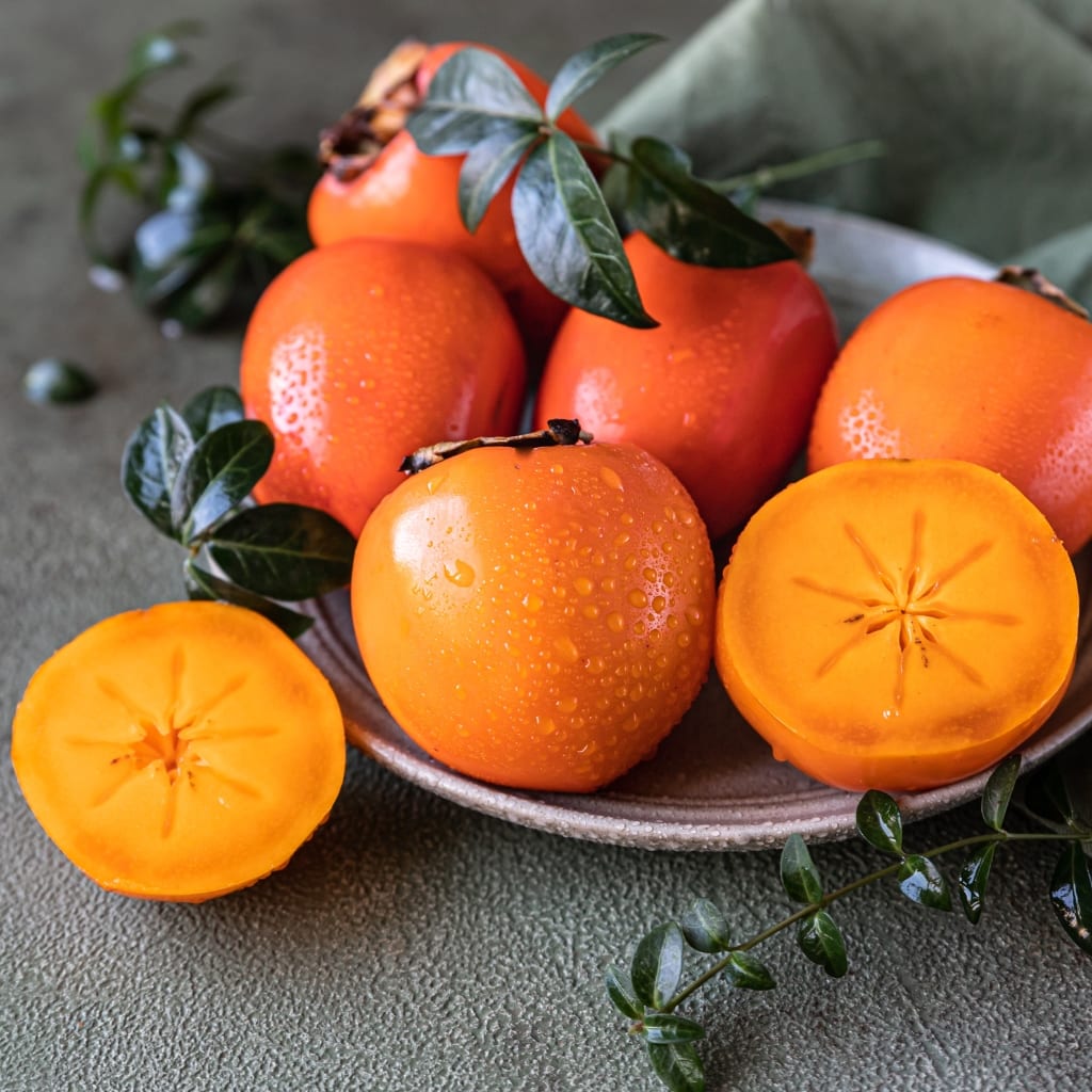 Fresh, Moist With Dews, Ripe Persimmons on a Plate