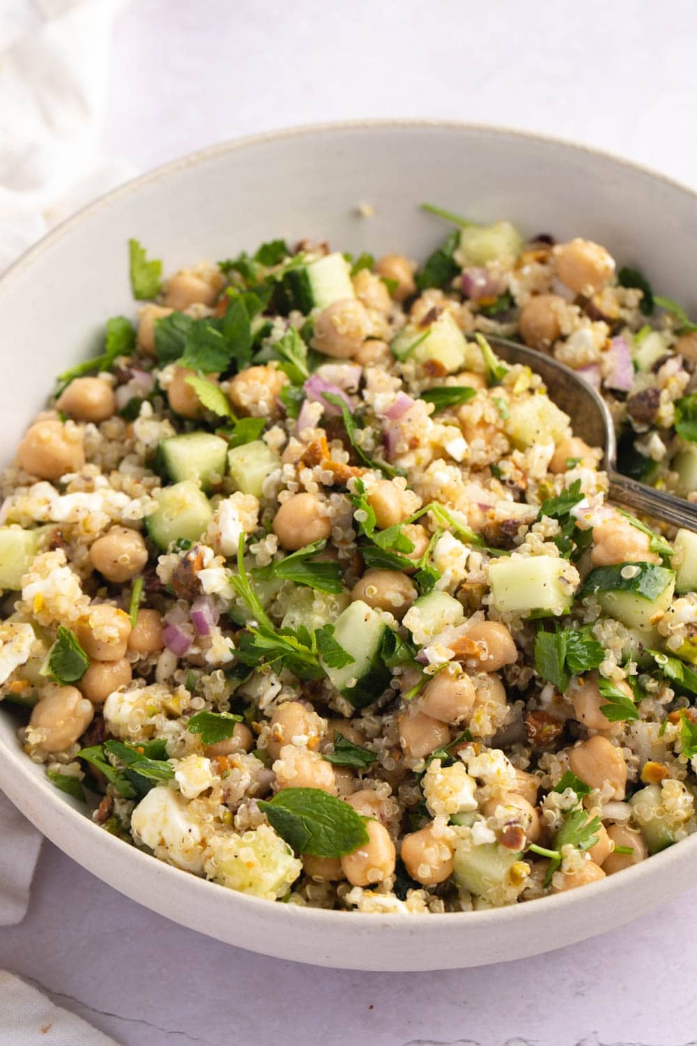 Jennifer Anniston Salad with Quinoa, Cucumber, Parsley and Onions in a White Bowl