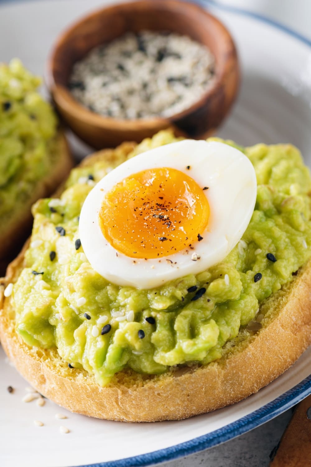 Avocado Toast with Spread and Slice of Boiled Egg, Sprinkled With Sesame Seeds