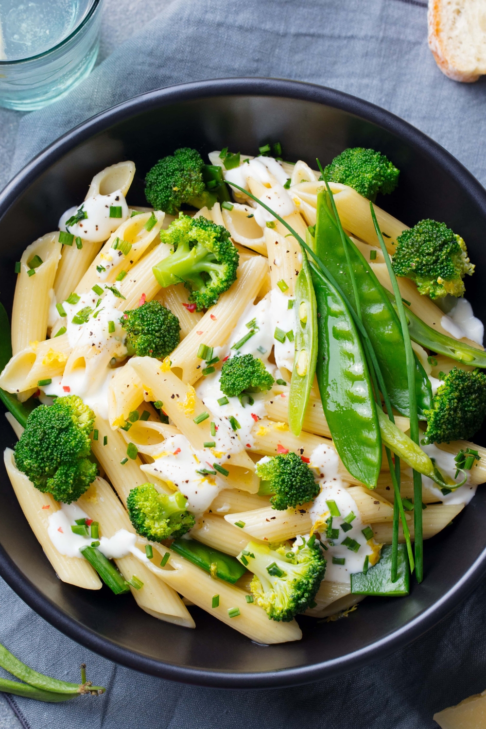 Pasta with Broccoli, Peas and Creamy Sauce, Garnished With Pepper and Chopped Onion Leaves