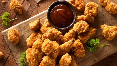 Homemade Popcorn Chicken with Ketchup in a Wooden Board