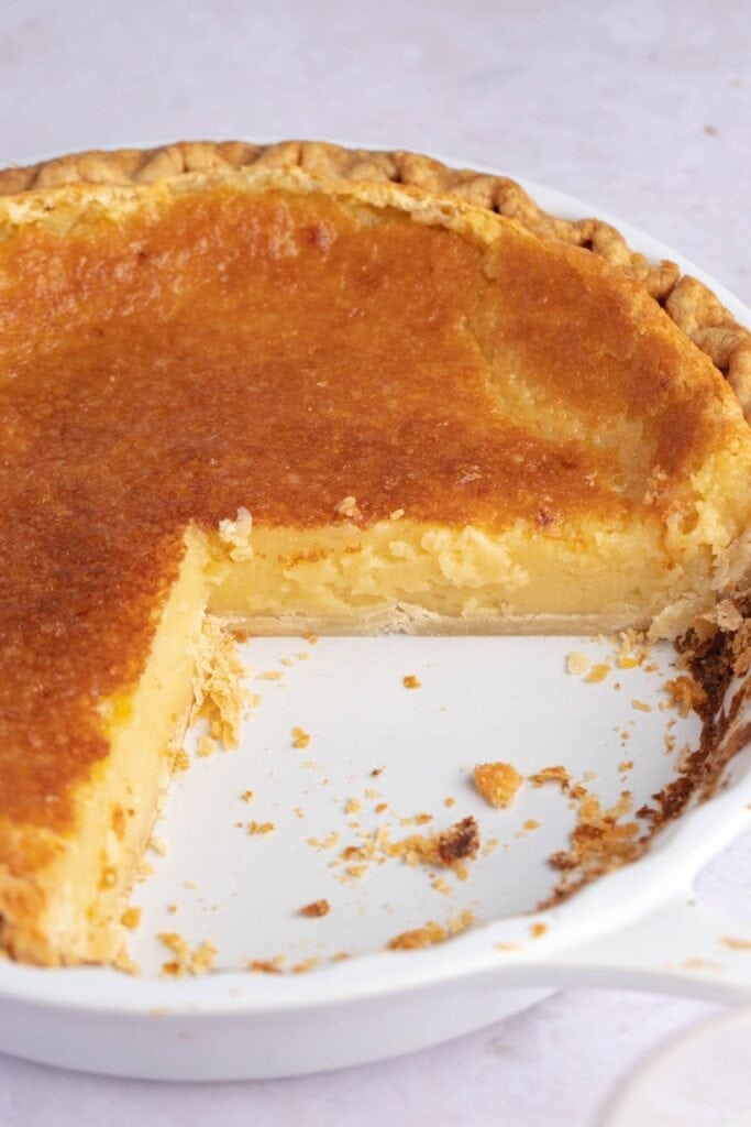Homemade silky eggnog pie in a baking dish with a slice cut out