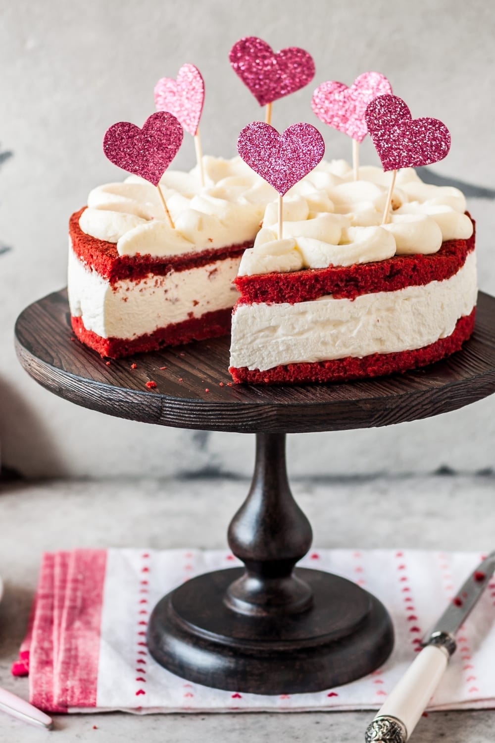 Valentine's Day Cheesecakes featuring Homemade Sliced Red Velvet Cheesecake Served on a Wooden Cake Tray