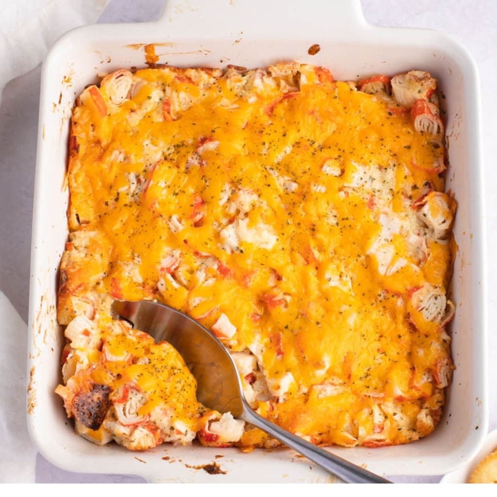 Cheesy Crab Casserole on a White Rectangular Baking Dish With Spoon 