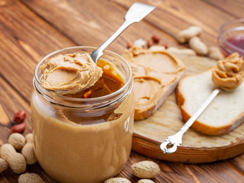 Creamy Peanut Butter on a Jar Scooped With a Spoon