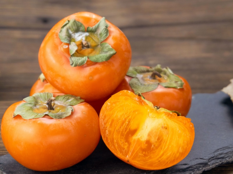 Whole and Sliced Ripe Persimmons