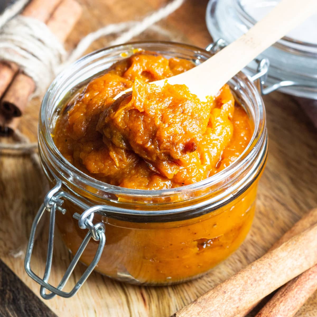 Pumpkin Butter on Small Jar Scooped with a Wooden Spoon
