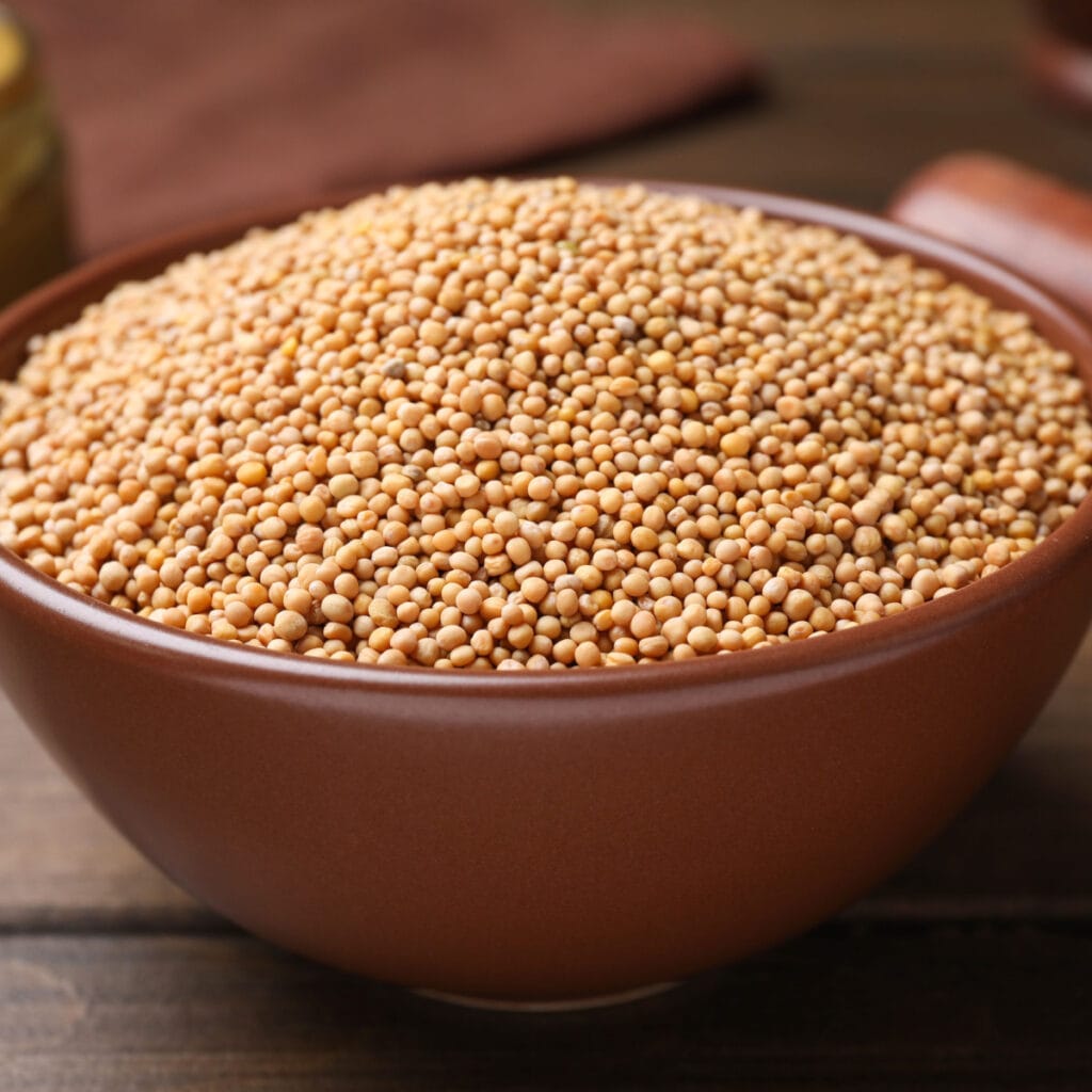 A Bowl of Yellow Mustard Seeds on a 
Wooden Table