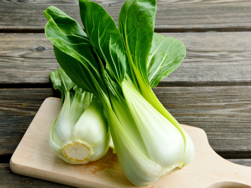 Two Whole Bok Choy in a Wooden Cutting Board