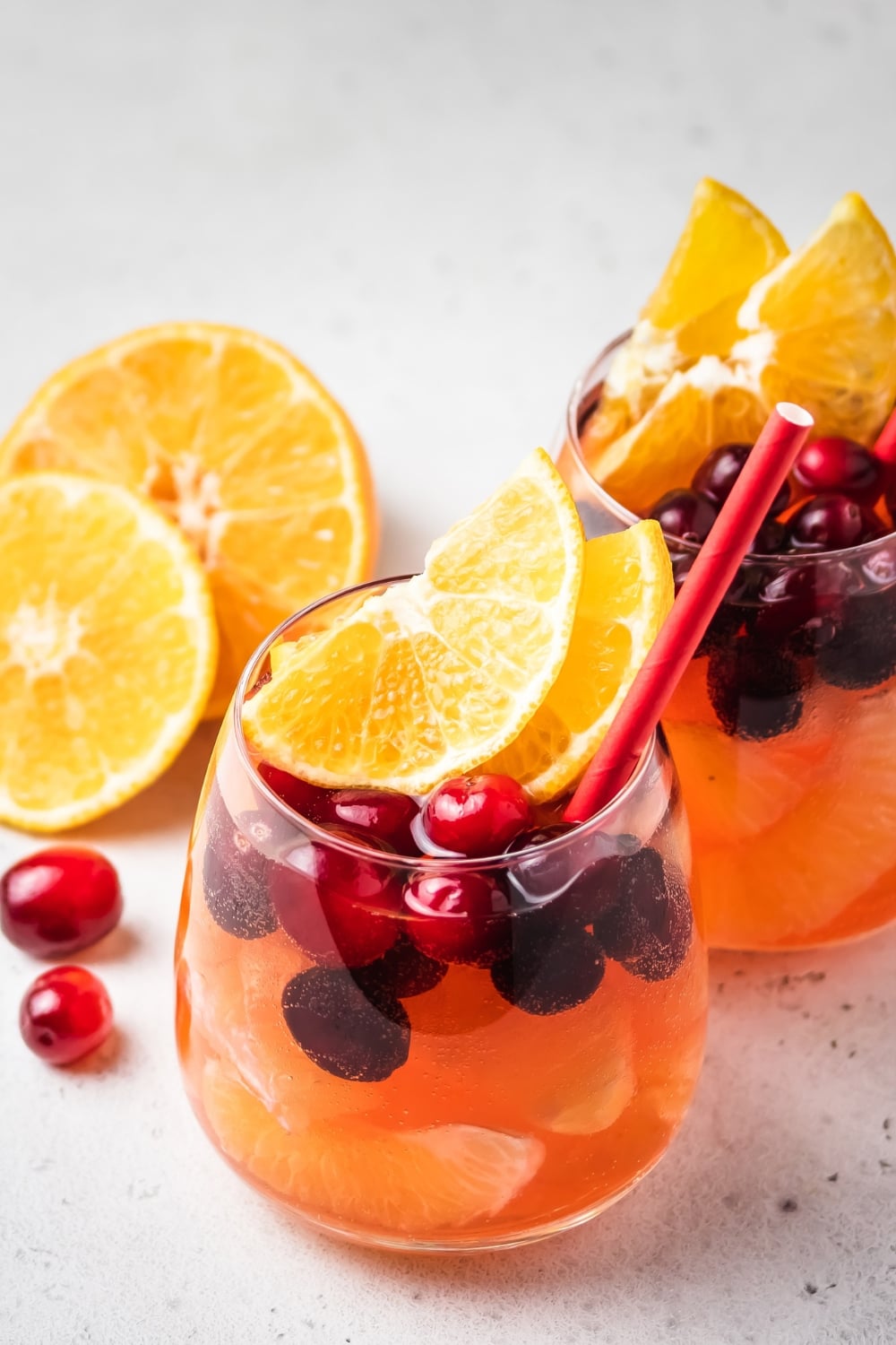 Two Glasses of Boozy Cranberry Champagne Punch with Oranges and Fresh Cranberries
