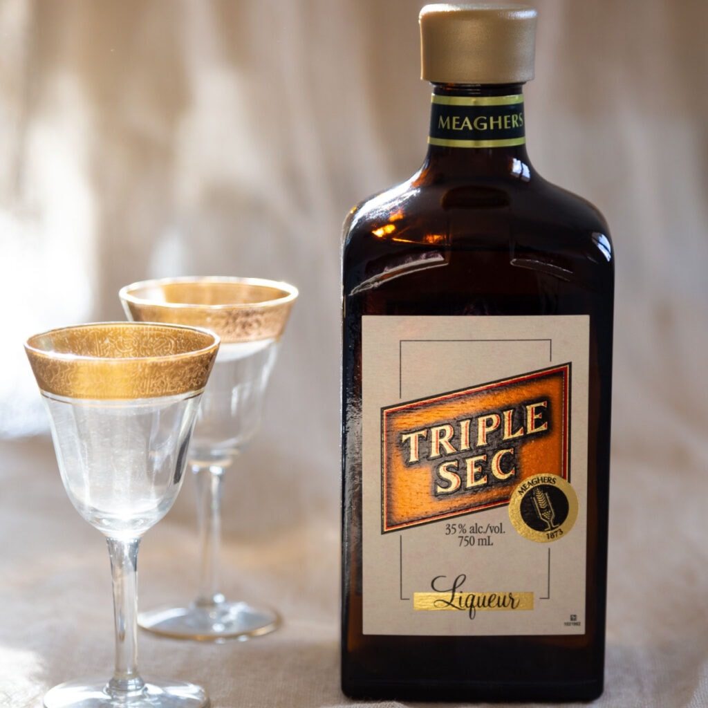 Bottle of Triple Sec with two empty glasses
