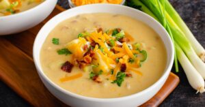 Bowl of Homemade Potato Soup with Cheese, Bacon and Green Scallions