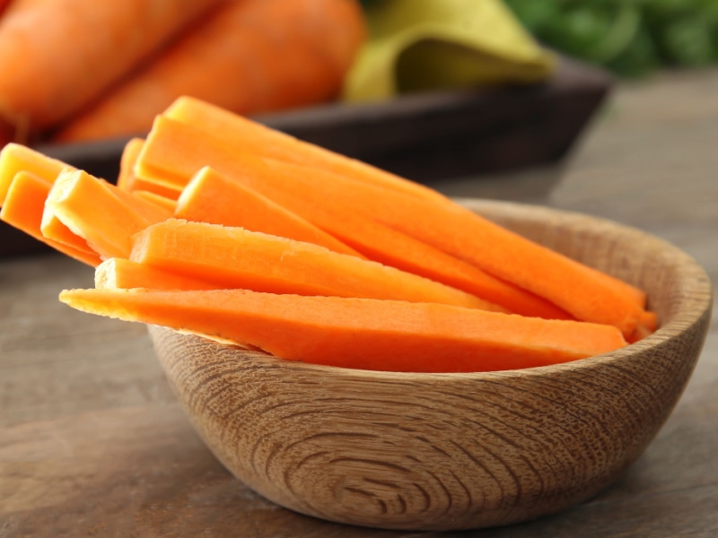 Raw Carrot Sticks on a Wooden Bowl