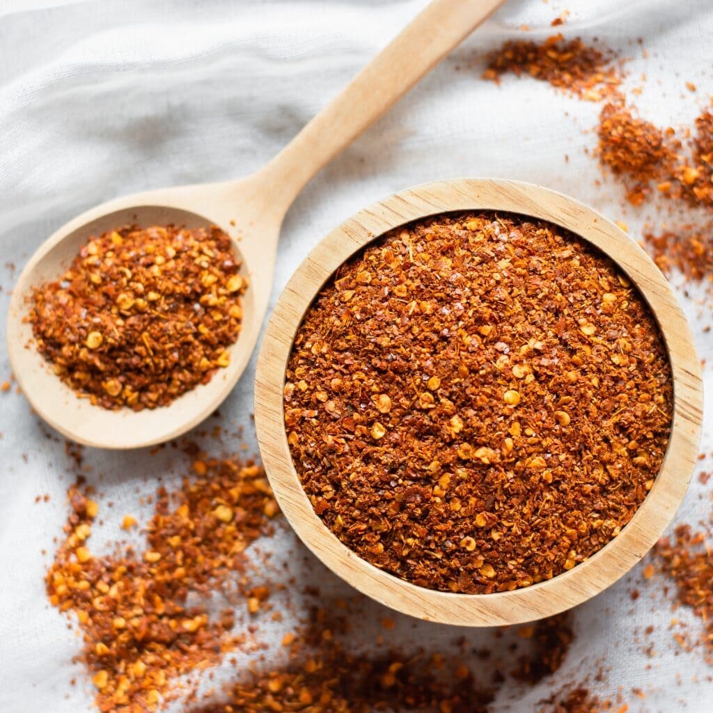 Cayenne Pepper Powder in Wooden Spoon and Bowl