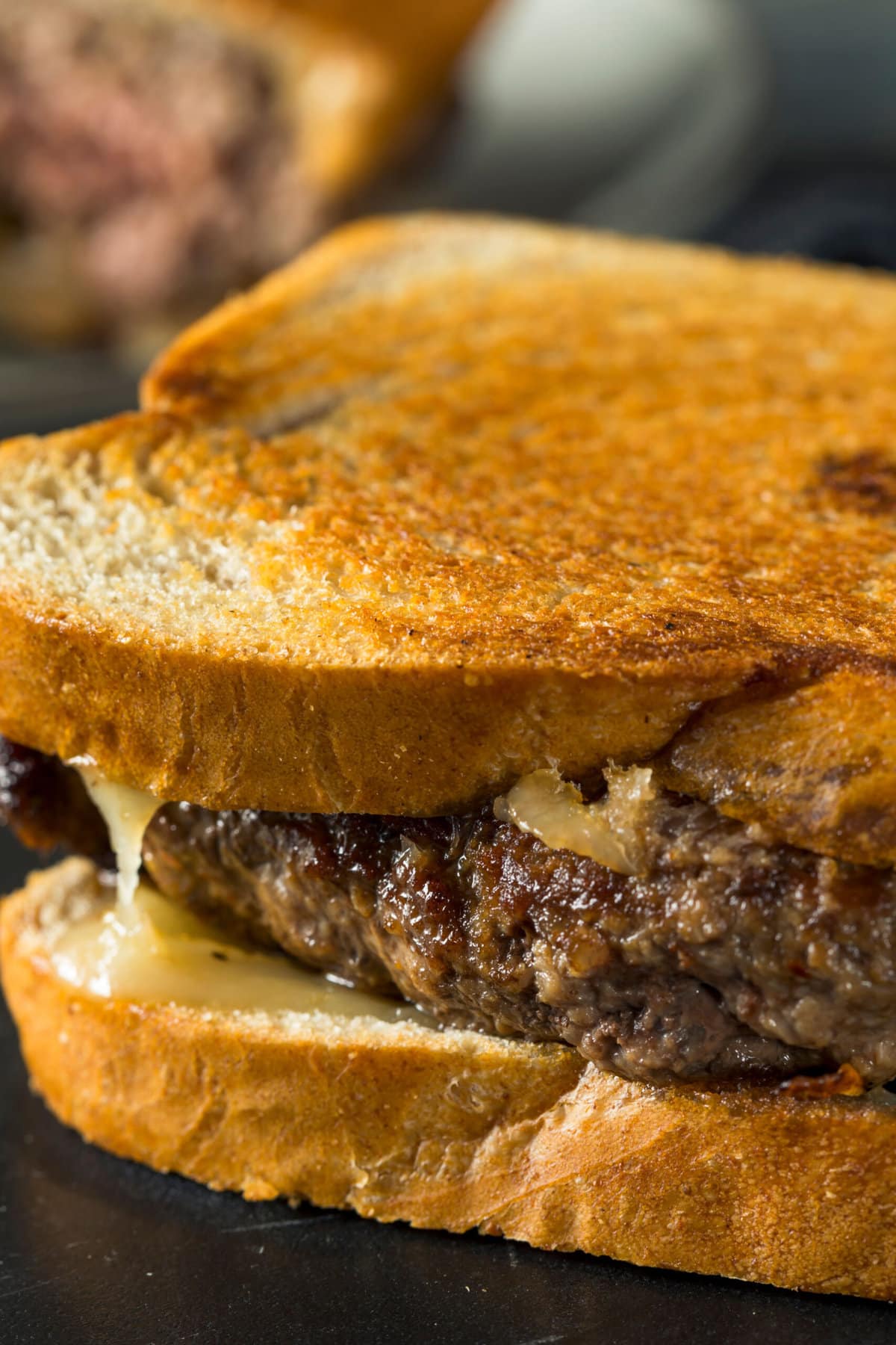 Closeup of Sandwich With Thick Beef Patty and Melting Cheese
