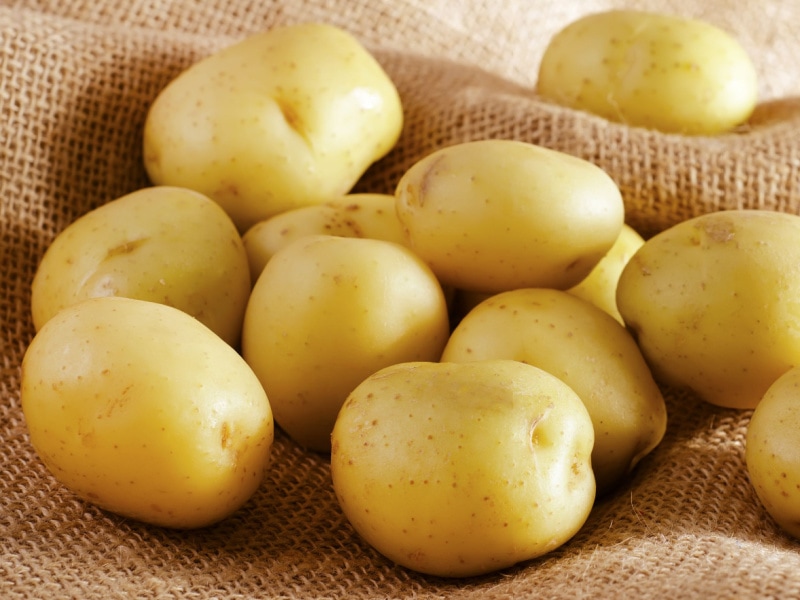 Round Yellow Potatoes on Top of a Rustic Cloth Sack