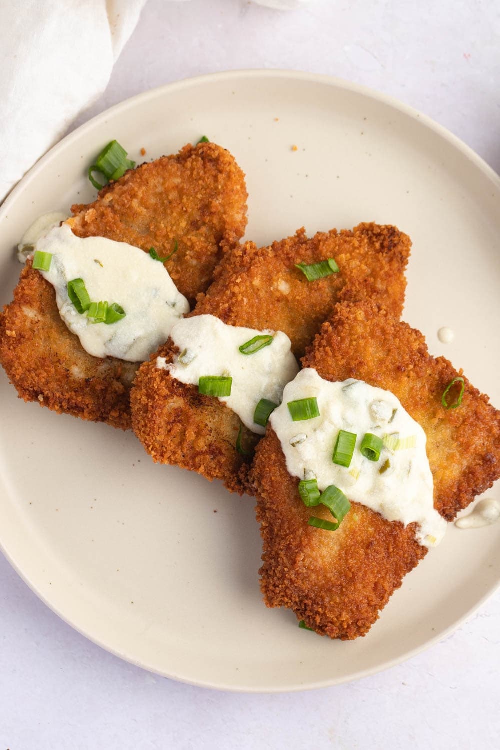 Crispy Soft and Juicy Pork Cutlets with Sour Cream and Chopped Chives on Top