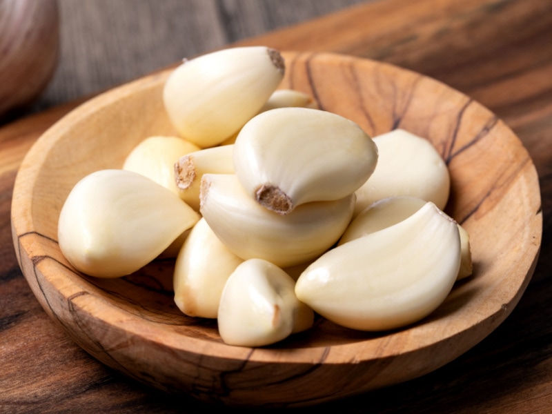 Fresh Cloves of Garlic in a Wooden Saucer