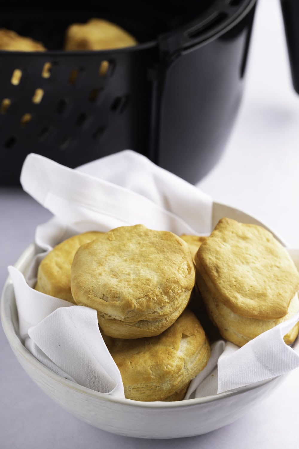 A bunch of biscuits from air fryer on a bowl with paper lining. 