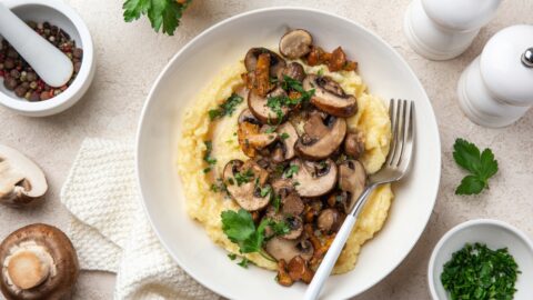 Homemade Creamy Polenta with Fried Mushrooms in a White Plate