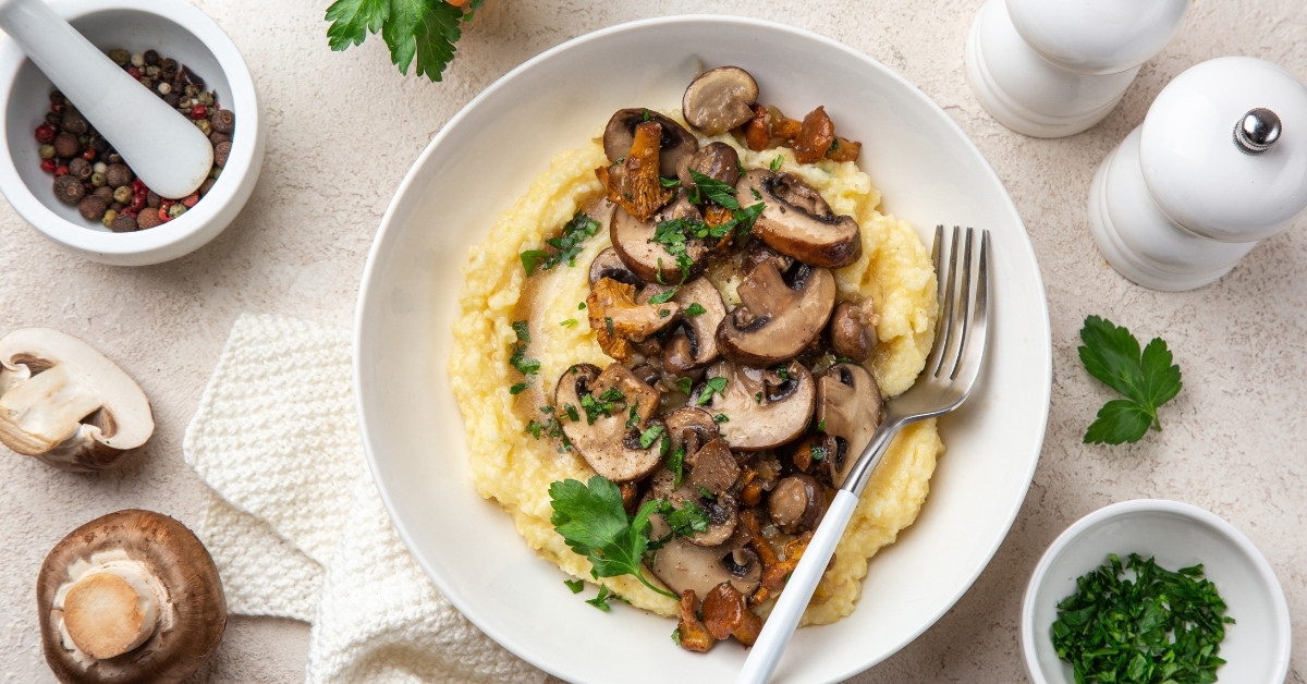 Homemade Creamy Polenta with Fried Mushrooms in a White Plate