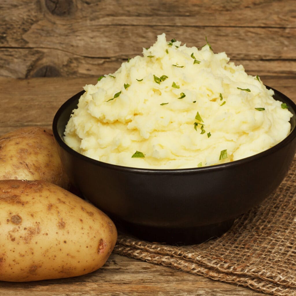 Raw Potatoes and Mashed Potatoes in a Brown Bowl