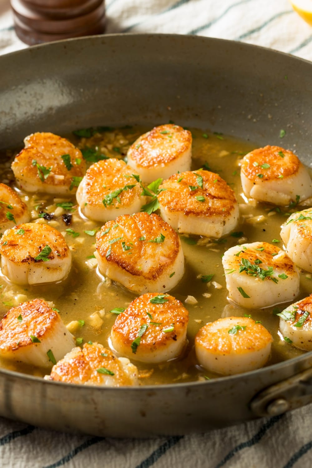 Pan-Seared Scallops with Garlic and Broth, Garnished With Chopped Parsley Leaves