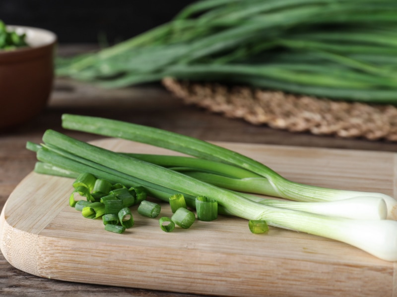 Whole and Chop Scallions on a Wooden Cutting Board