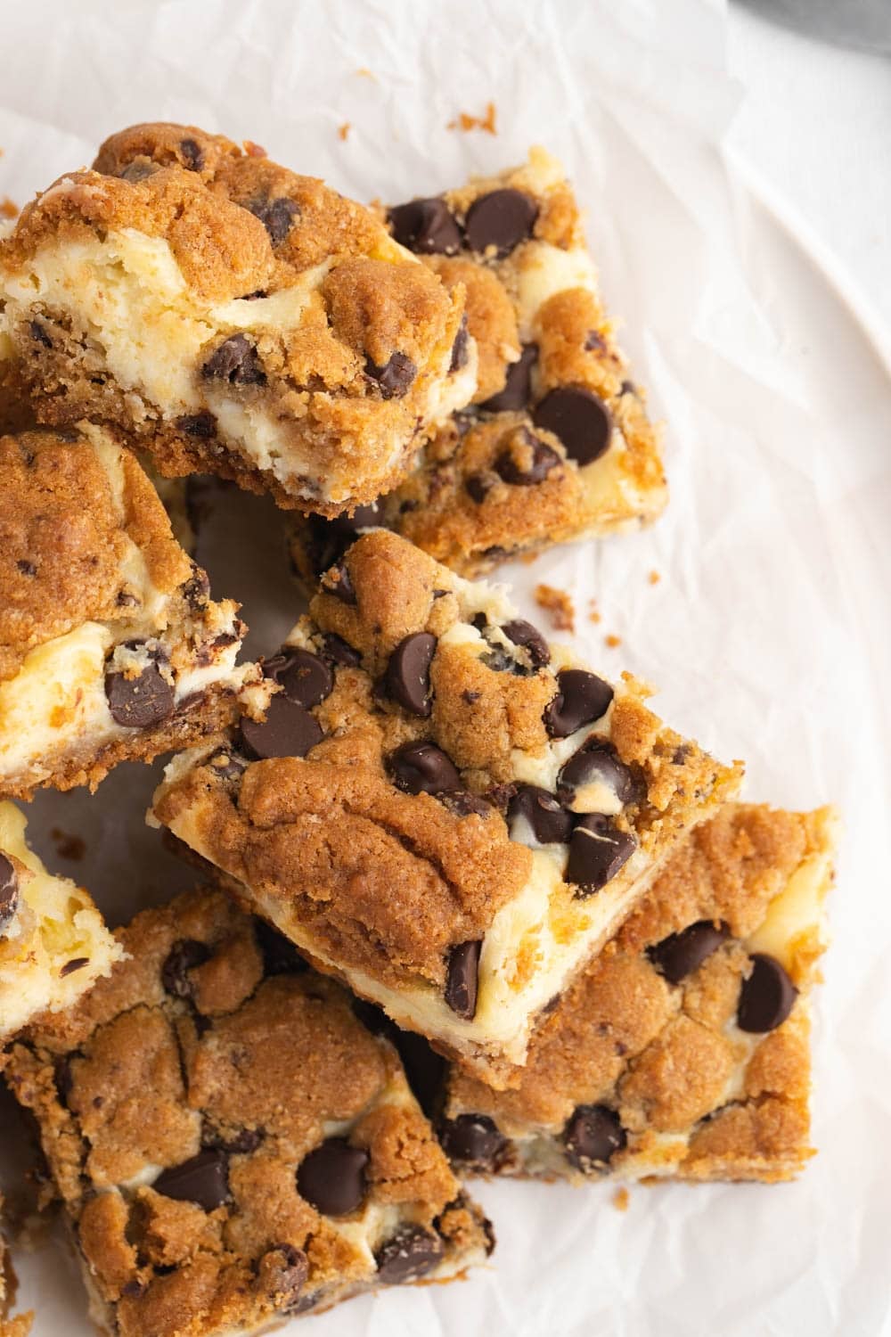 Sliced Chocolate Chip Cheesecake Bars on a Parchment Paper