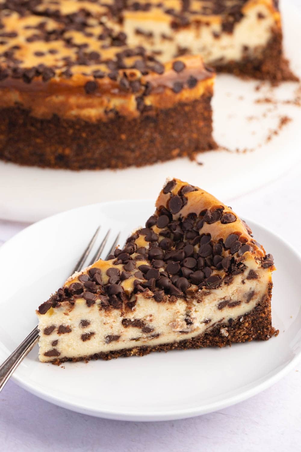 A  Loaded Slice of Chocolate Chip Cheesecake in a White Plate