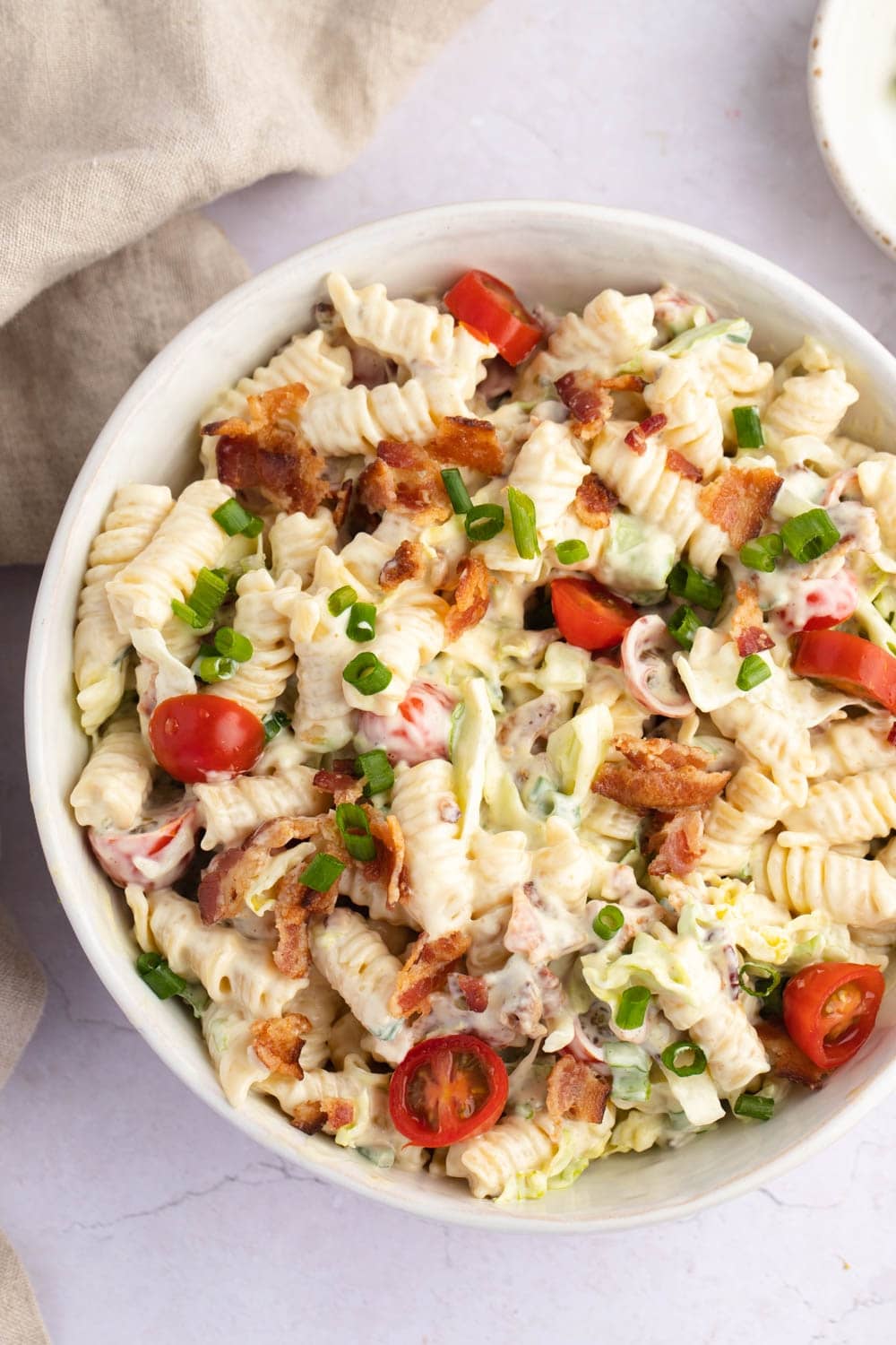 BLT Pasta Salad on a Bowl Made with Crispy Bacon, Tomatoes, Lettuce, Dressing and Scallions