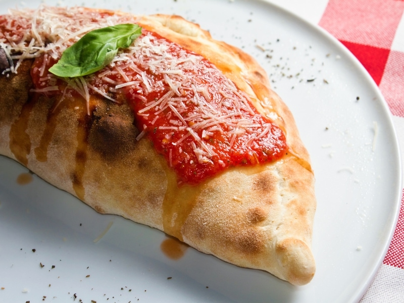 Calzone Pizza Garnished With Sauce
