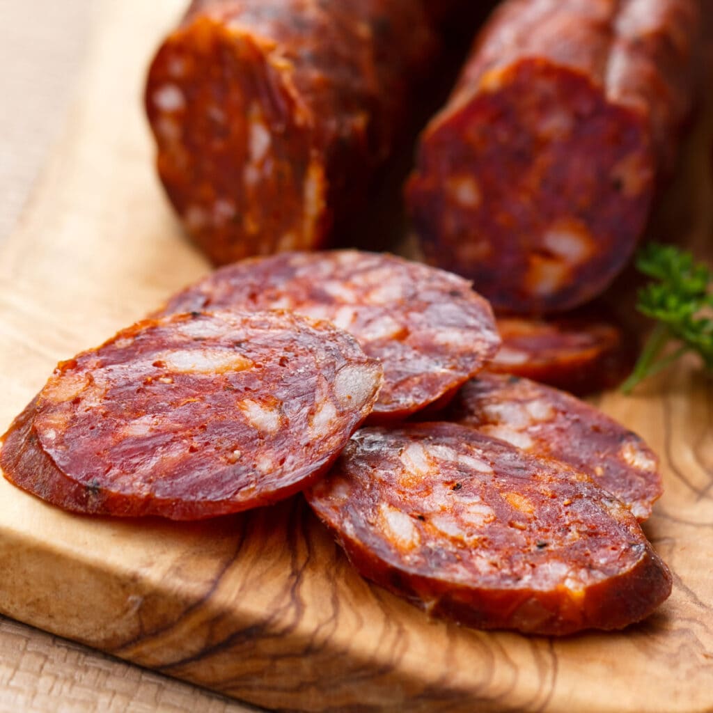 Sliced Chorizo Sausage with Parsley on a Wooden Cutting Board