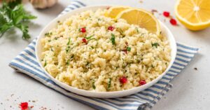 Cooked Couscous in a Ceramic Plate with Lemon and Pomegranate