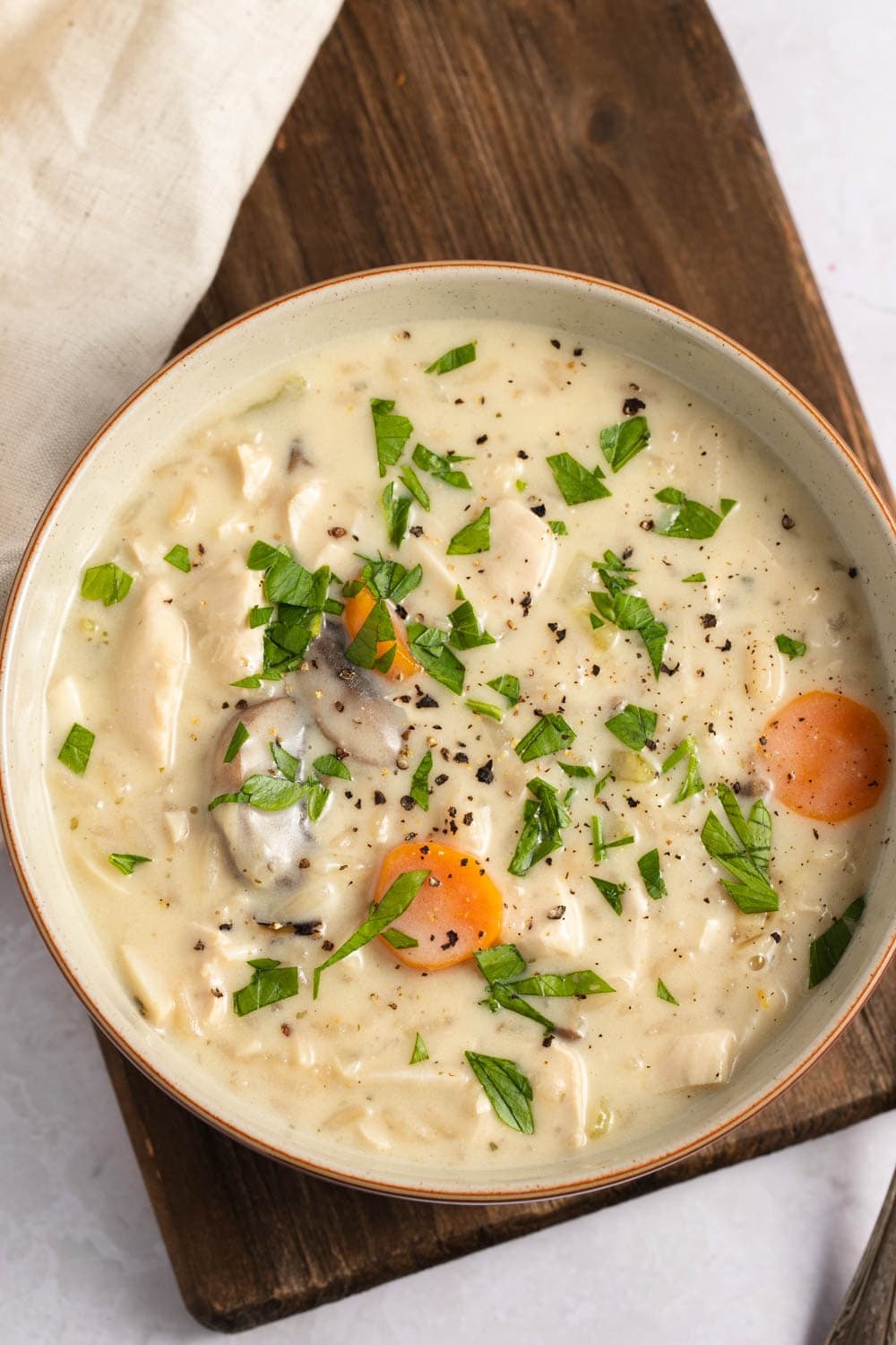 A bowl of creamy homemade chicken and wild rice soup with mushroom and carrots.