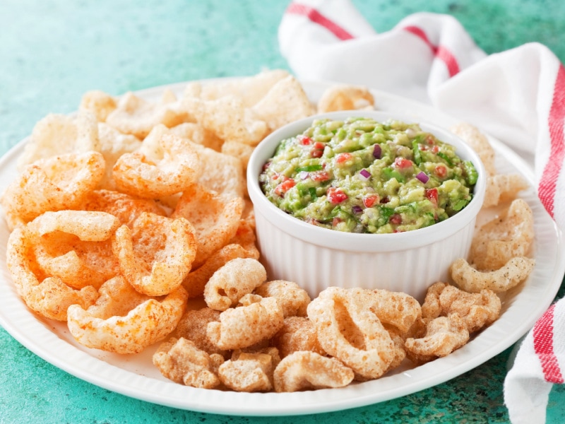 Pork rinds on a platter with guacamole