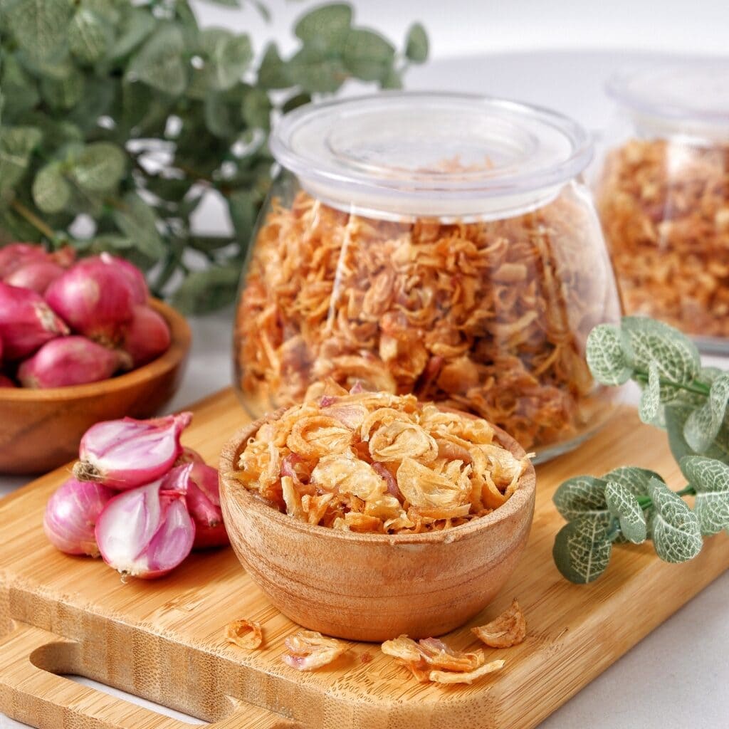 Fried shallots on two jars and a wooden bowl. 