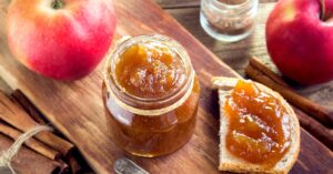 Glass of Apple Butter with Fresh Apples and Cinnamon
