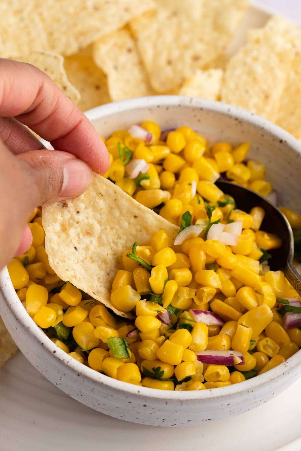 Chips dipped in corn salsa. 