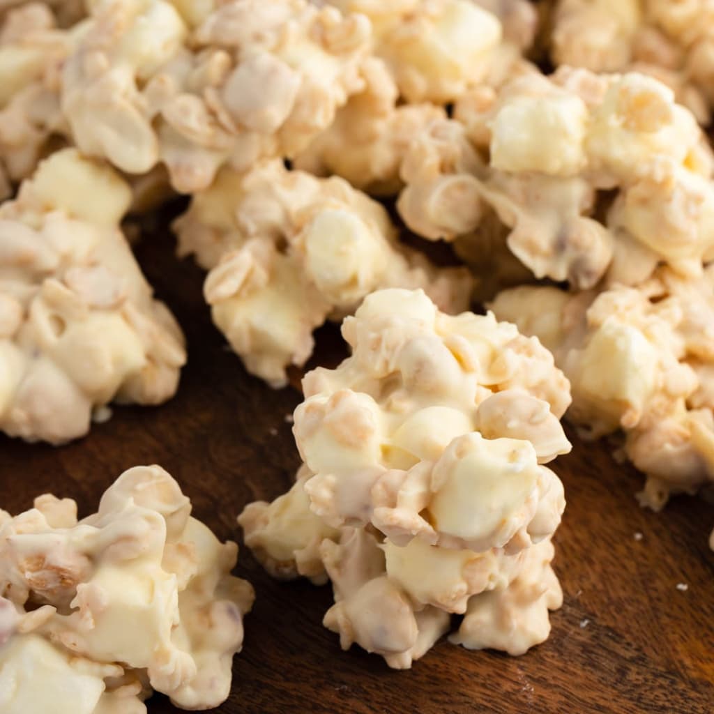 Closeup view of White chocolate covered Rice Krispies on a wooden cutting board. 