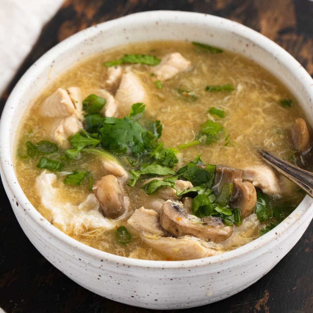 Hot and Sour Chicken Soup with Mushroom and Herbs in a Bowl