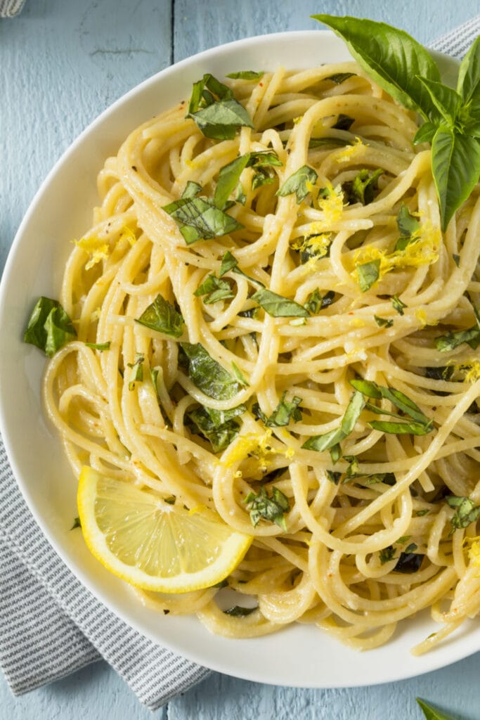 Lemon Spaghetti Garnished With Lemon Zest and Fresh Basil Leaves
