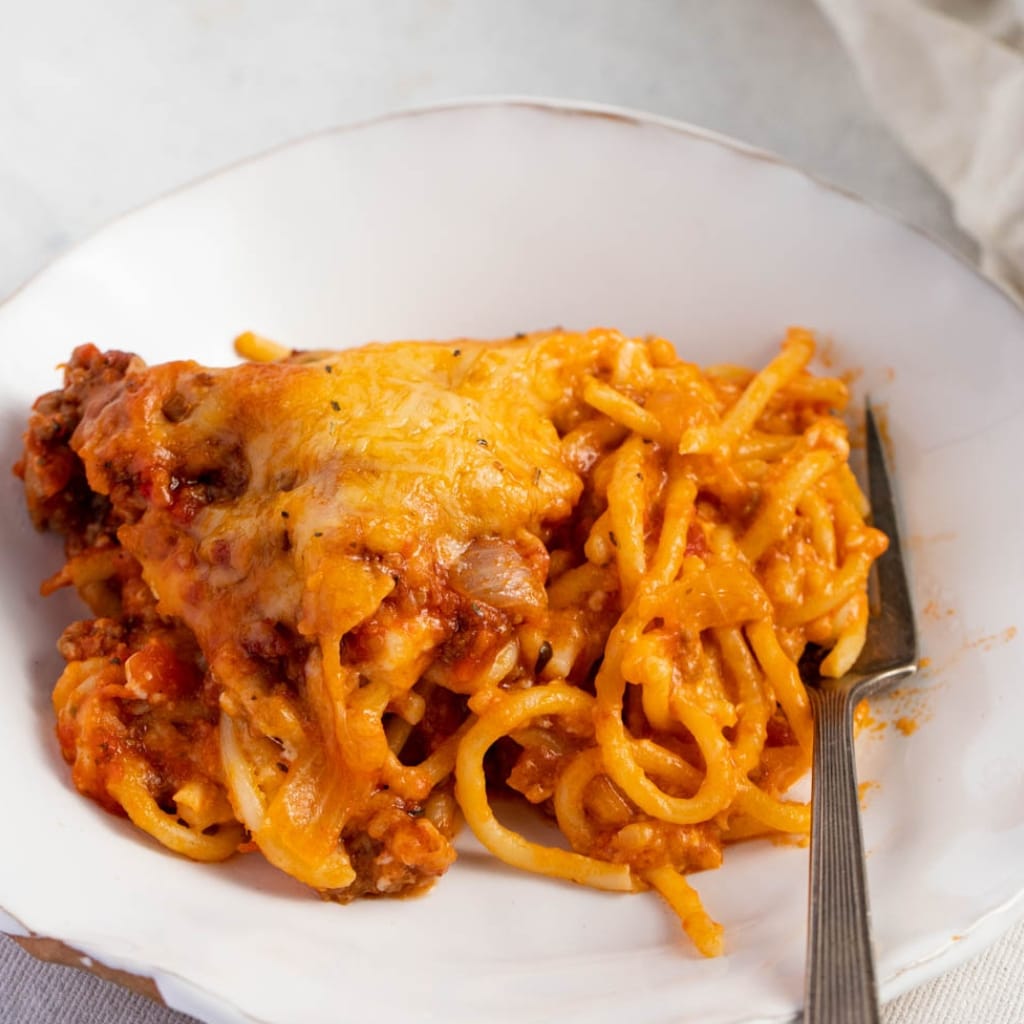 Serving of Cheesy Baked Spaghetti on a  Plate With Fork