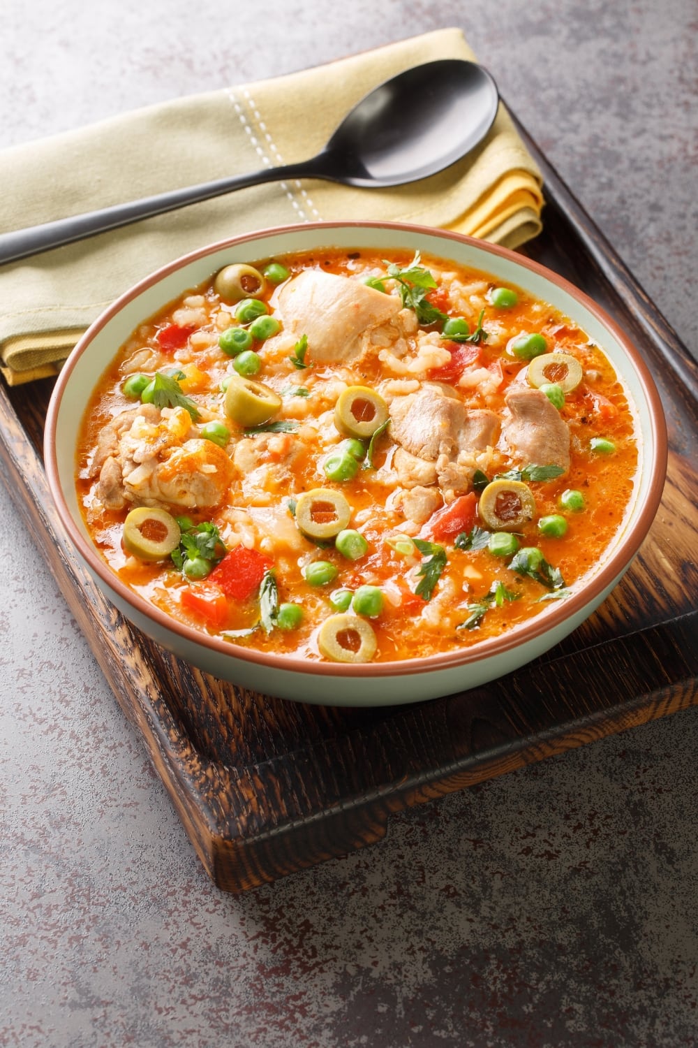 Bowl Traditional Puerto Rican Asopao de Pollo Made With Rice, Chicken, Olives, Green peas and Tomatoes